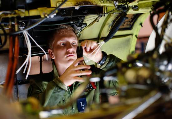 En flysystemlærling jobber på et F-16 jagerfly ved Bodø flystasjon
A technical apprentice repairing a F-16 plane at Bodø air station