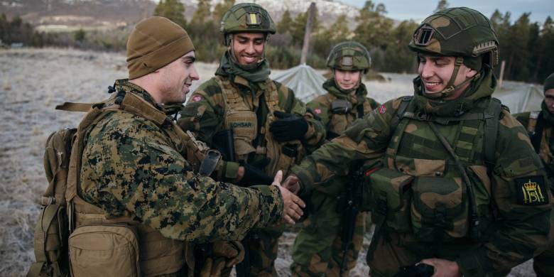 Gardister fra Hans Majestet Kongens Garde snakker med korporal King fra US Marine Corps under NATO-øvelsen Trident Juncture 2018 i Oppdal

