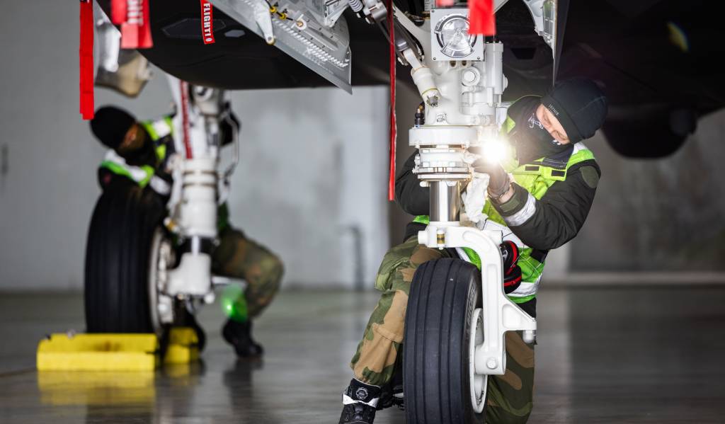 Teknisk personell inspiserer et F-35 i et shelter i Poznań, Polen.