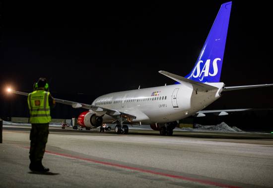 Strategisk luftevakueringsflyet fra SAS som har fraktet Hans Majestet Kong Harald hjem fra Malaysia lander på Oslo lufthavn Gardermoen. Å takser inn på den militære flystasjonen. 