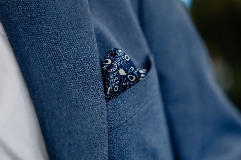 Et elegant silketørkle stikker opp av en dresslomme.