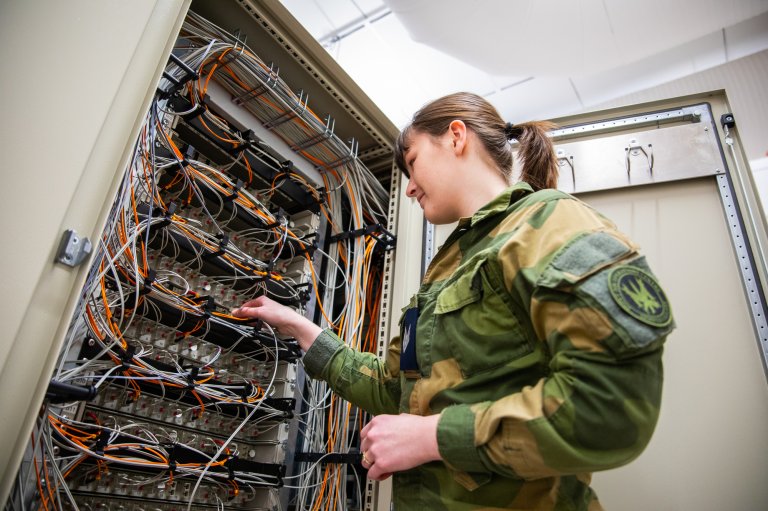 En CIS-tekniker patcher fiber i et patcheskap i Air Ops under NATO-øvelsen Nordic Response 2024. Foto: Fabian Helmersen, Forsvaret