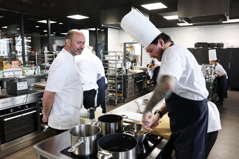 kokker og dommer i arbeid på et kjøkken.