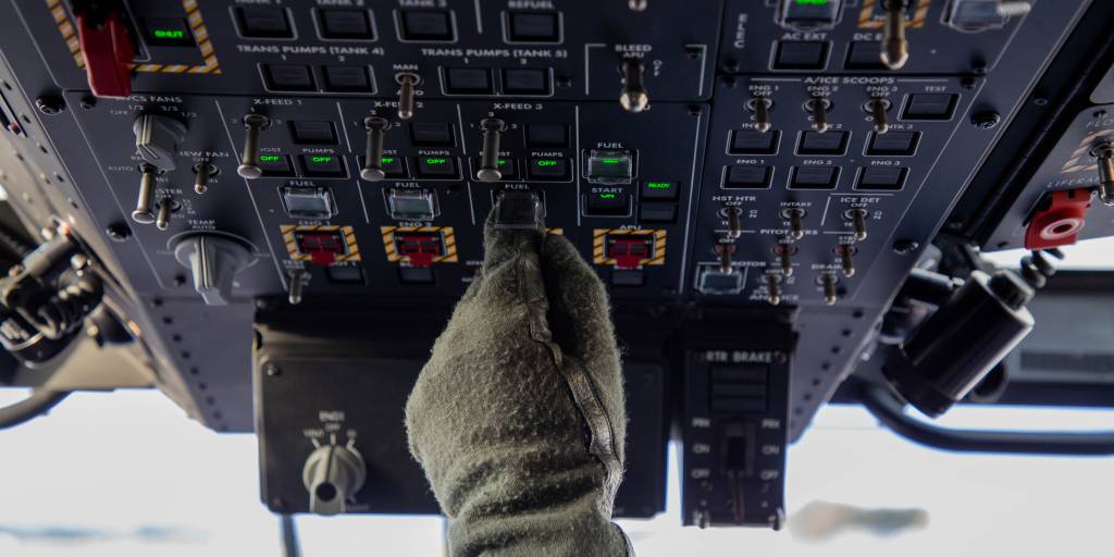 Helikopterflyger trykker på knapper i cockpit