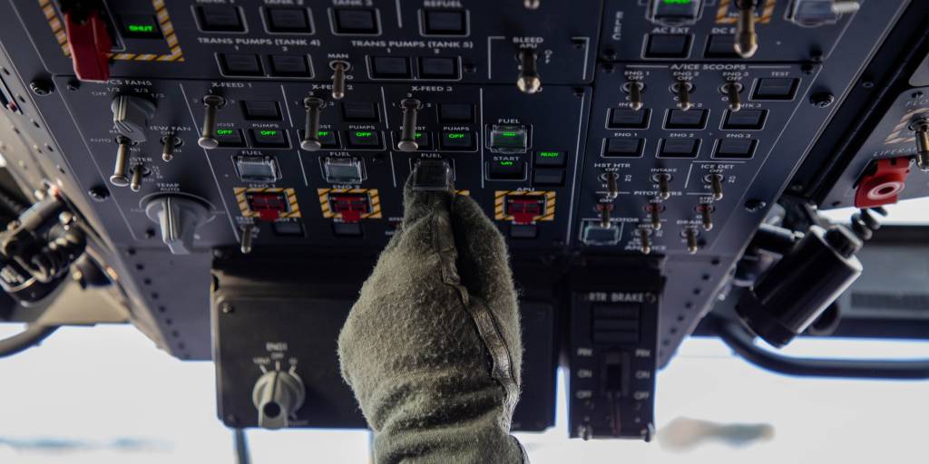 Helikopterflyger trykker på knapper i cockpit