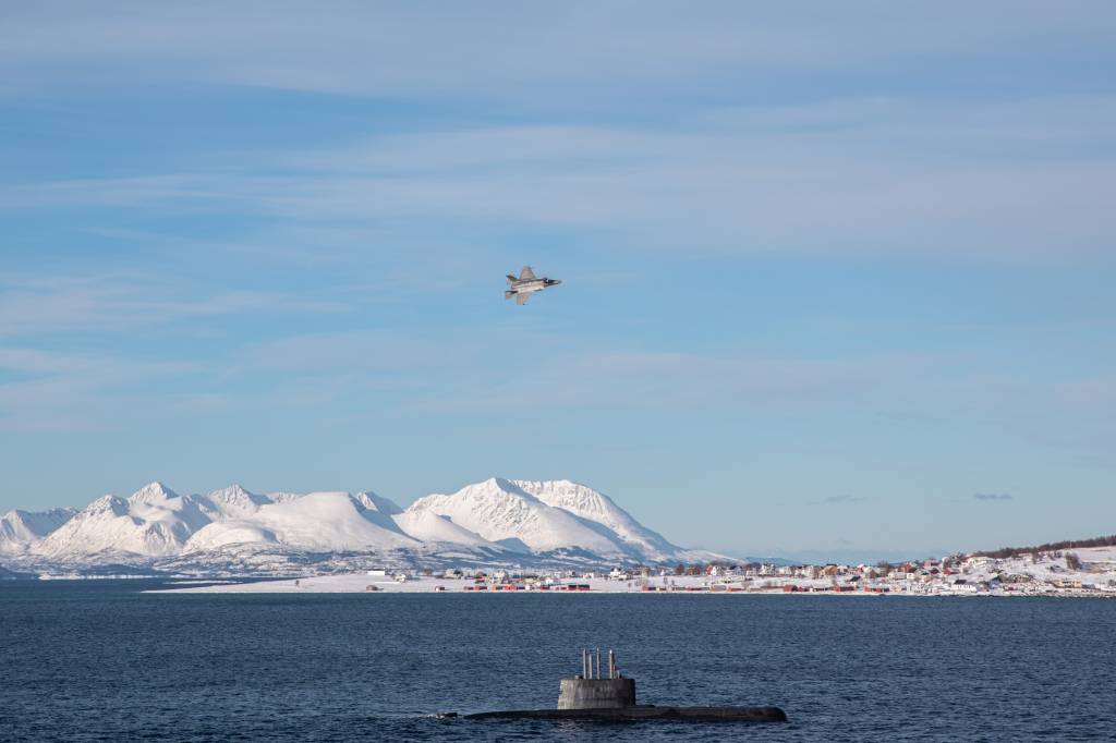 Det norske kampflyet F-35 flyr over ubåten KNM 