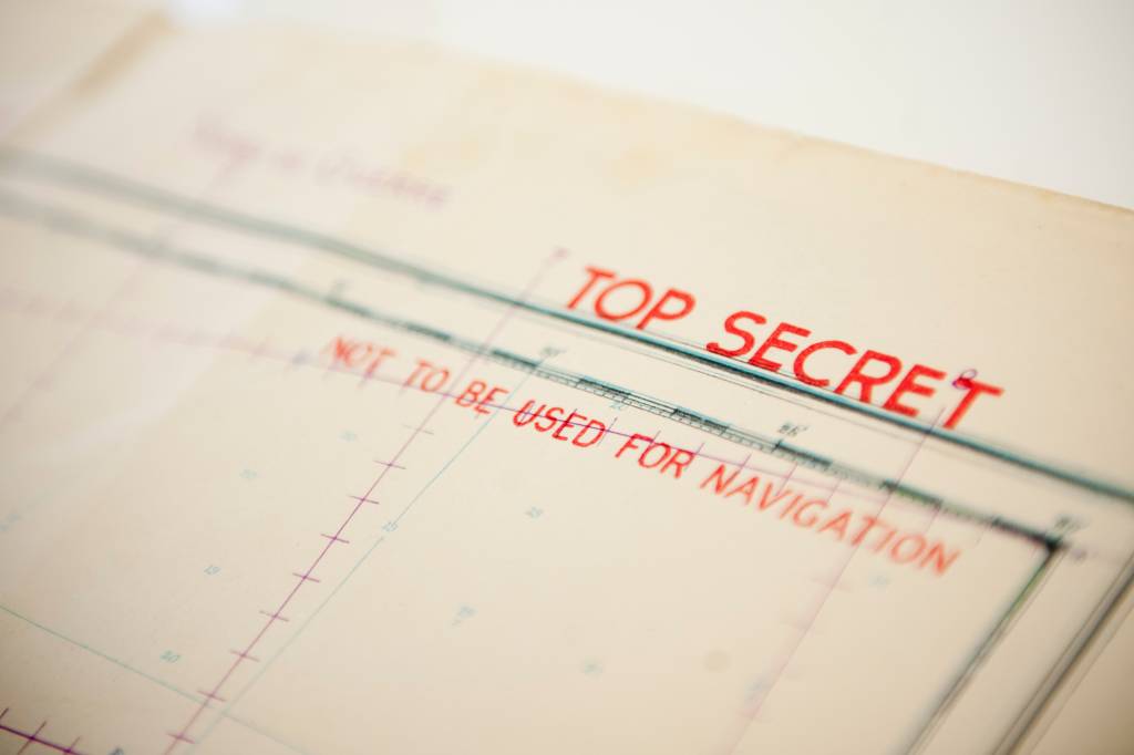 NEW LONDON, Conn. -- Coast Guard Museum curator Jennifer Gaudio, Lt. Michael Bell, Lt. Shawn Simeral, and Chief Petty Officer Terry Harmon look over nautical charts Feb. 24, 2014, which were used onboard a landing craft infantry (LCI) during D-Day. The charts were preserved by Coast Guard coxswain Al Green, who piloted a LCI during the D-Day invasion and took possession of the charts as he was egressing his damaged LCI. U.S. Coast Guard photo by Petty Officer 3rd Class Cory J. Mendenhall. Original public domain image from Flickr