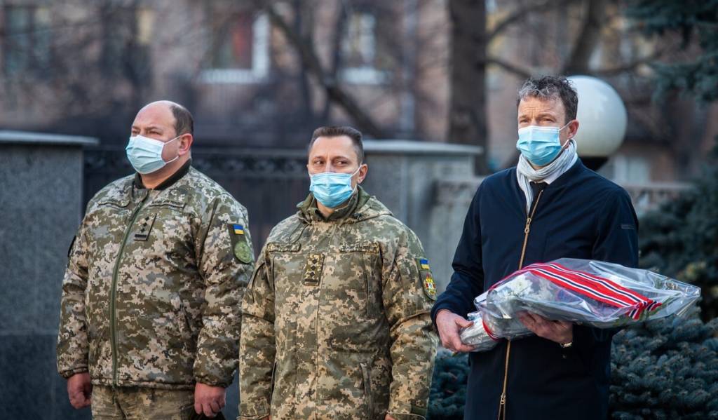 Legger ned blomst med drapert norsk flagg ved minnesmerket for de falne ved den ukrainske Forsvarsstaben i Kyiv 16. november 2021