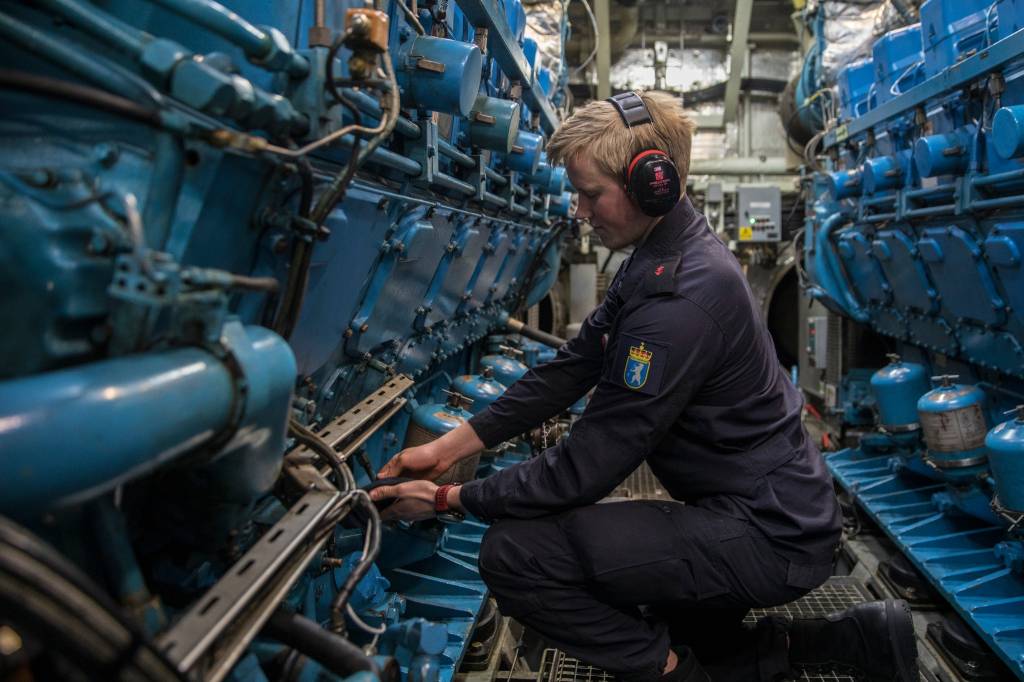 Maskinist på KNM Roald Amundsen går sjekkrunde i maskin.  /  Machinists checks the oil on machine