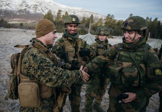 Gardister fra Hans Majestet Kongens Garde snakker med korporal King fra US Marine Corps under NATO-øvelsen Trident Juncture 2018 i Oppdal

