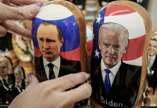 A customer shows to photographer a traditional Russian wooden dolls called Matreska of Russian President Vladimir Putin, center, and U.S. President Joe Biden, center right, at a souvenirs store in Moscow, Russia, Monday, Dec. 6, 2021. The Kremlin says President Joe Biden and Russian President Vladimir Putin will speak in a video call Tuesday. (AP Photo/Pavel Golovkin)