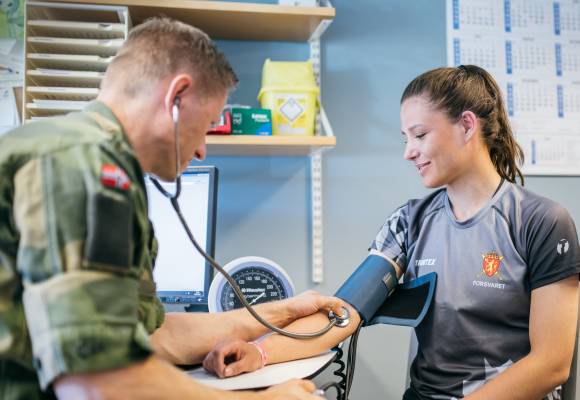 Kvinne måler blodtrykk hos lege