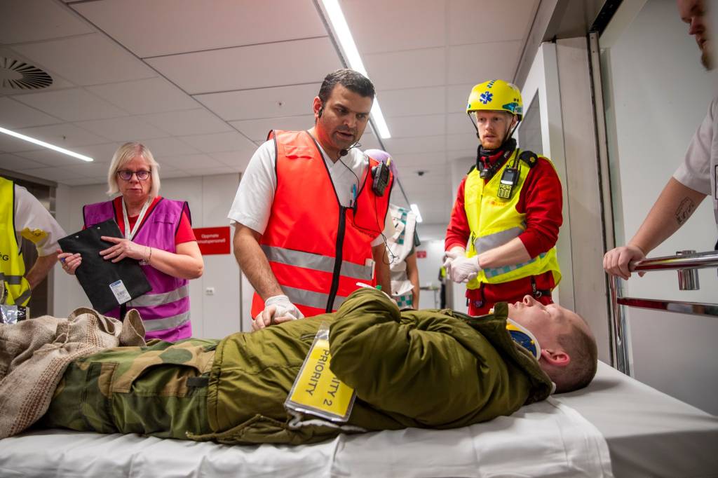 En markør som spiller skadet blir tatt imot på akuttmottaket på sykehuset i Tromsø. Totalforsvaret med politi, brannvesen, helsevesenet, Sivilforsvaret, Heimvernet, Norsk folkehjelp og Forsvaret. Gjennomførte en massetilstrømings øvelse for å teste planverket til universitetssykehuset Nord-Norge, ved å ta imot rundt 80 markør på sykehuset etter en masseskade hendelse i Tromsø.