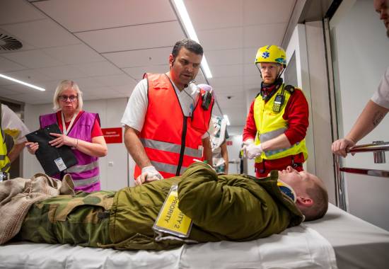 En markør som spiller skadet blir tatt imot på akuttmottaket på sykehuset i Tromsø. Totalforsvaret med politi, brannvesen, helsevesenet, Sivilforsvaret, Heimvernet, Norsk folkehjelp og Forsvaret. Gjennomførte en massetilstrømings øvelse for å teste planverket til universitetssykehuset Nord-Norge, ved å ta imot rundt 80 markør på sykehuset etter en masseskade hendelse i Tromsø.