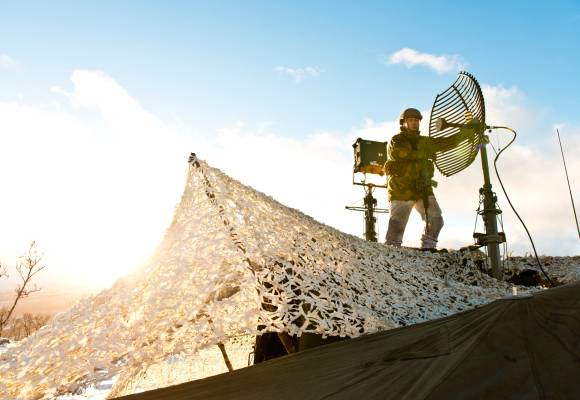 På grunn av kraftig vind, må antennene til knutepunktslaget i Sambandsbataljonen justeres jevnlig. /Soldiers from Signal Battalion adjust an UHF-antenna.