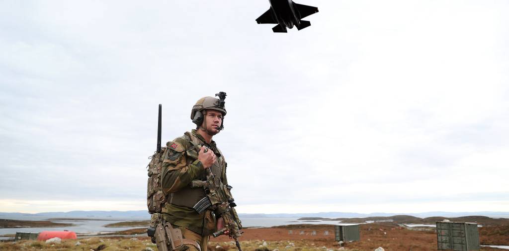 Et F-35A kamply passerer lavt over en soldat på Tarva skytefelt