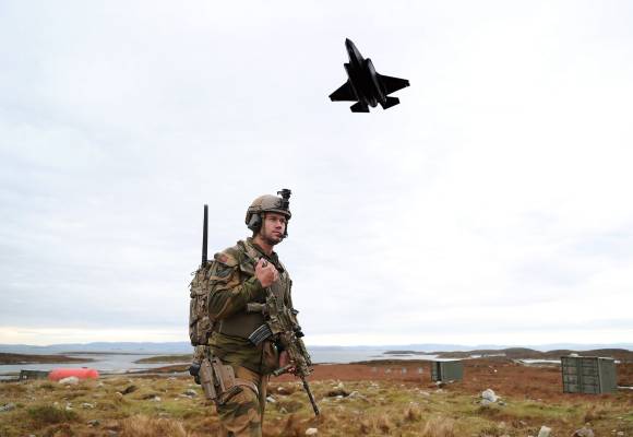 Et F-35A kamply passerer lavt over en soldat på Tarva skytefelt