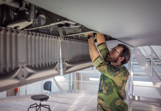 Tekniker skrur på vingen på en C-130j Hercules