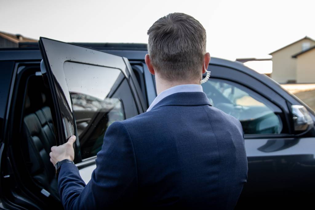 Militær livvakt kontrollerer sin sektor før VIP sitter opp. *** Local Caption *** Military bodyguard checks the car before VIP enters.