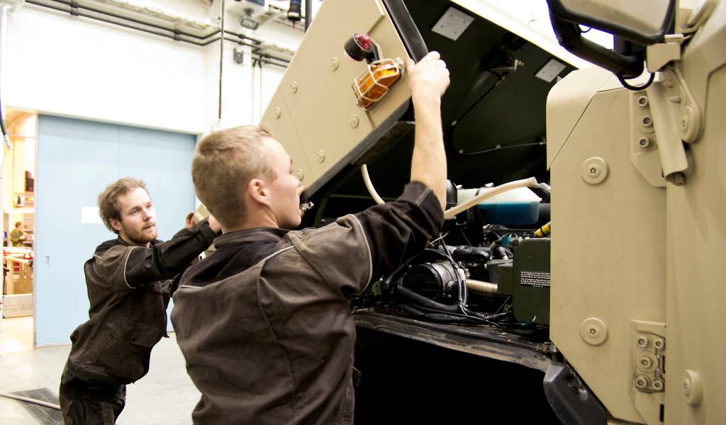 Elever ved Forsvarets tekniske befalsskole lukker panseret på en Dingo / Student at the non - commissioned offisers´training school works at a Dingo