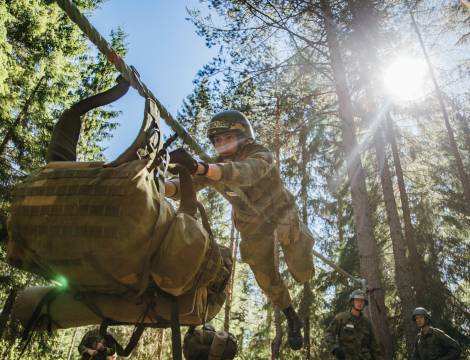 Kandidater har overfiring, der de må transportere seg selv og pakningen sin uten å treffe bakken. / Candidates are pulling themselves and their backpack across a rope, with the purpose of not touching the ground.